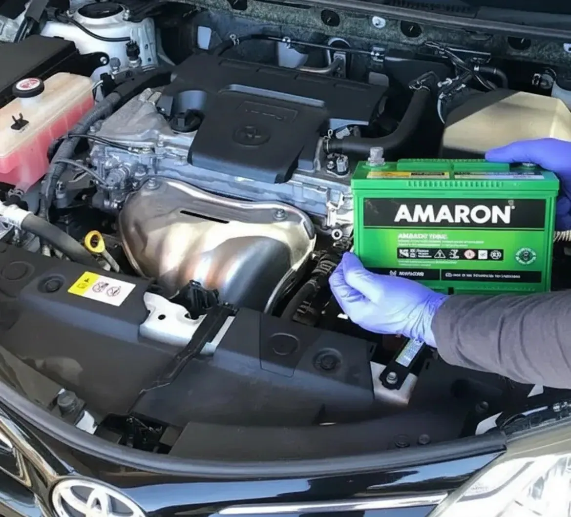 Gloved hand fitting a green Amaron battery