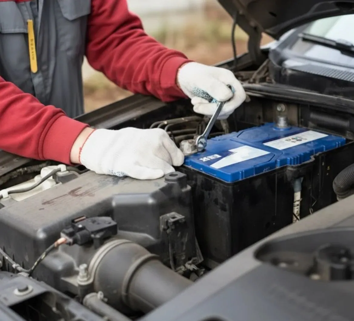 Why drivers call us Technician in red gloves working on a blue battery