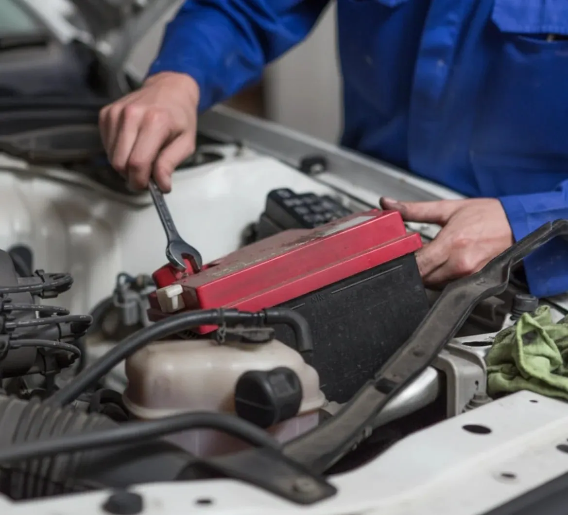 Why drivers call us Technician lifting a red battery