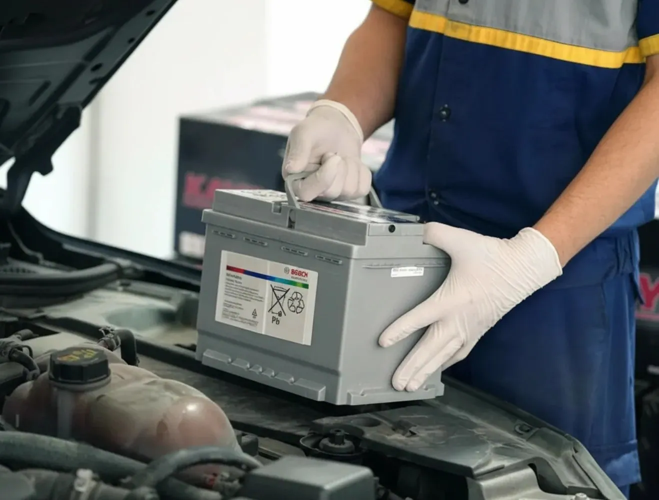 Technician lifting a silver battery