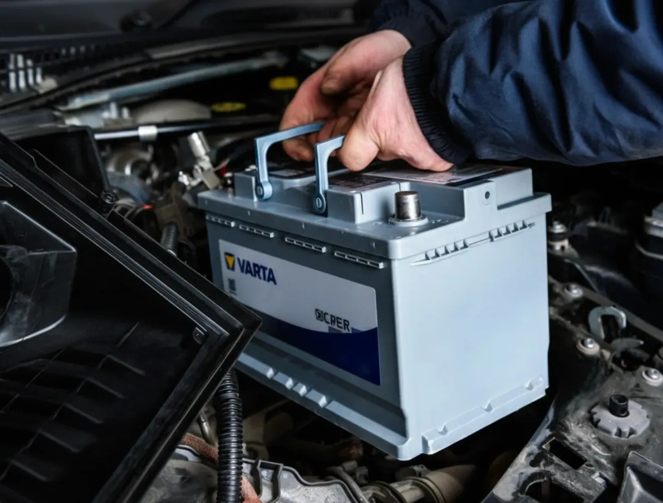 Hand lifting a Varta battery