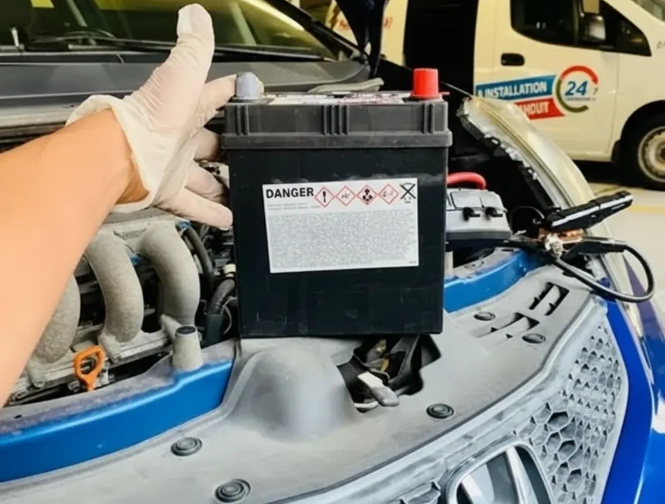 Gloved hand lifting a battery out