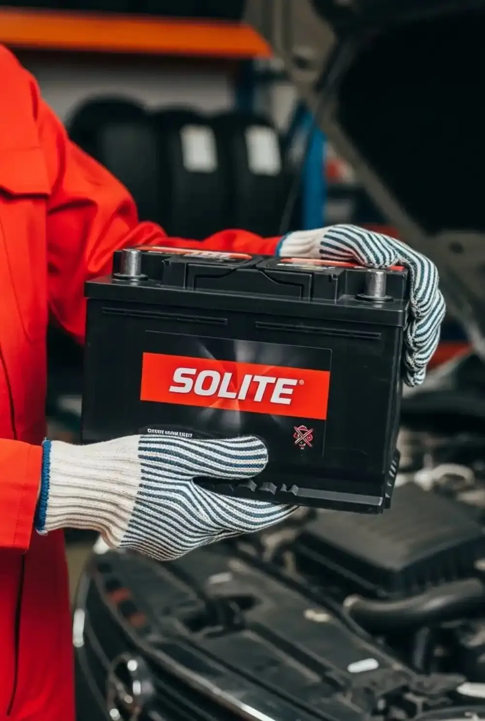 What we do for owners Technician in red holding a Solite battery