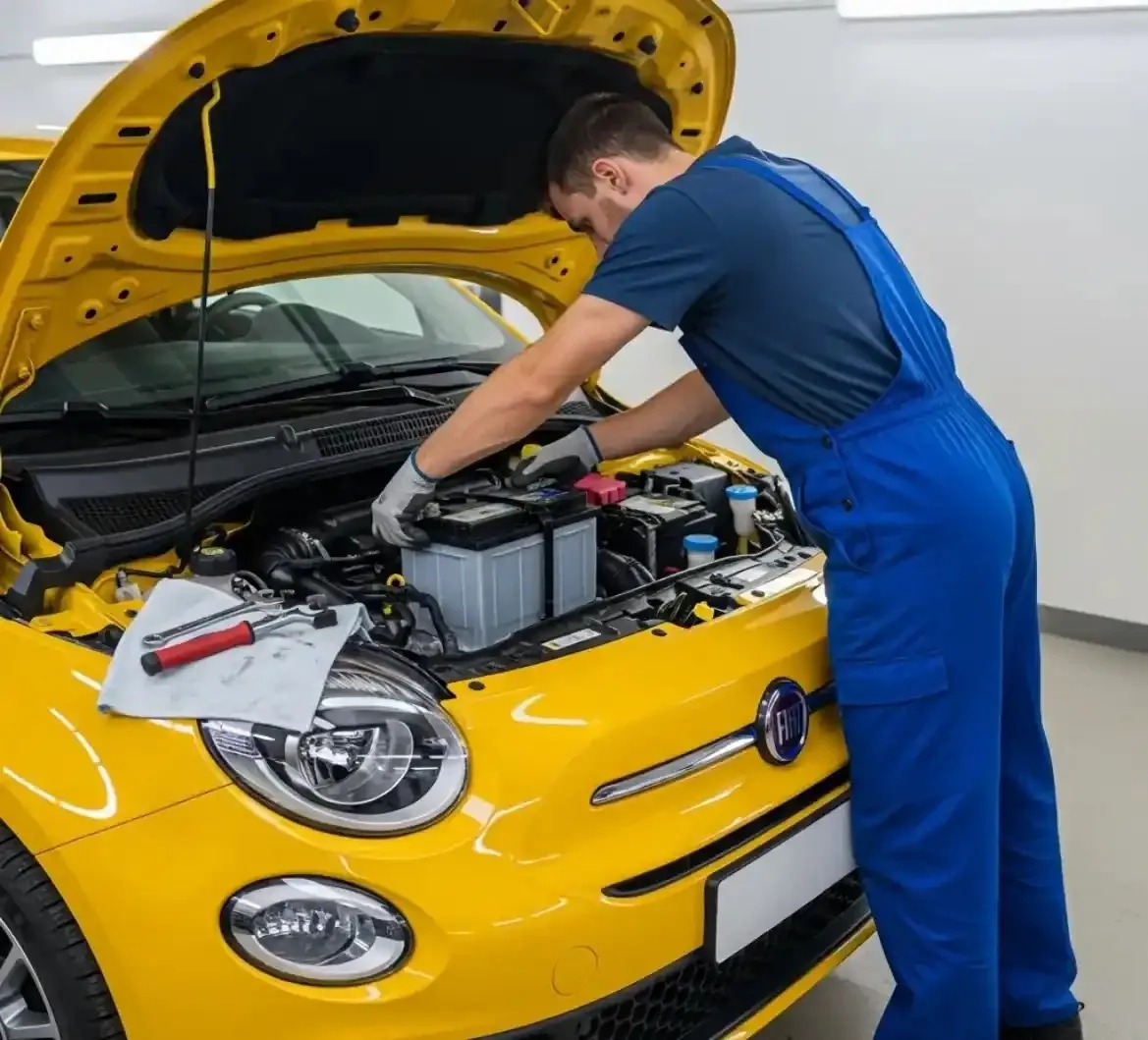 Our team on a Fiat Technician lifting a battery out of a yellow Fiat 500
